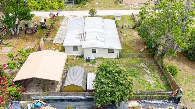 a aerial view of a house with swimming pool and large trees