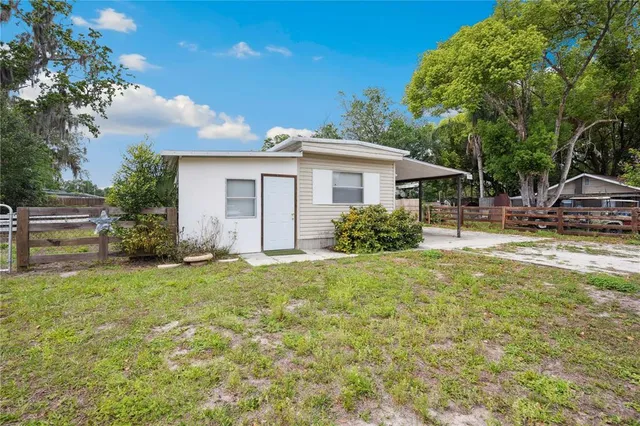 a view of a house with backyard and sitting area