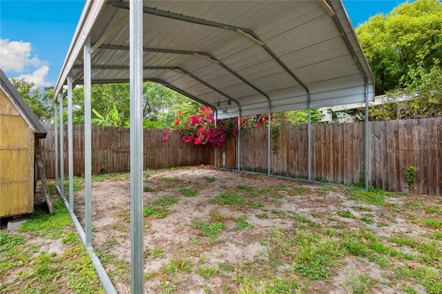 a backyard of a house with table and chairs under an umbrella