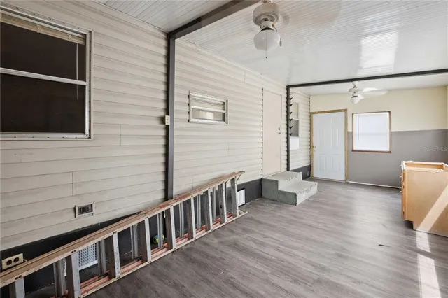a view of a hallway with wooden floor and staircase