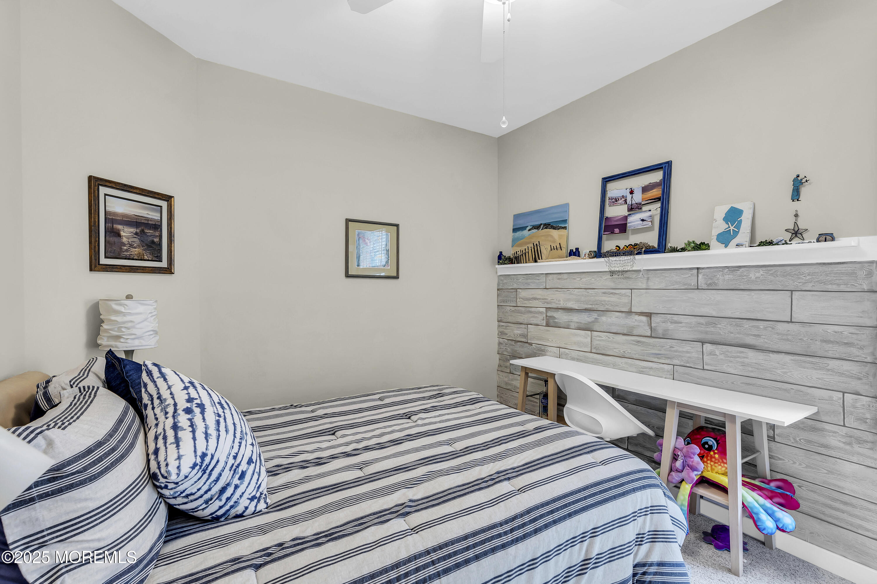 209 Beach Front, Unit 1 Manasquan, NJ 08736 - Photo 16 of 40 a bedroom with a bed and a chandelier