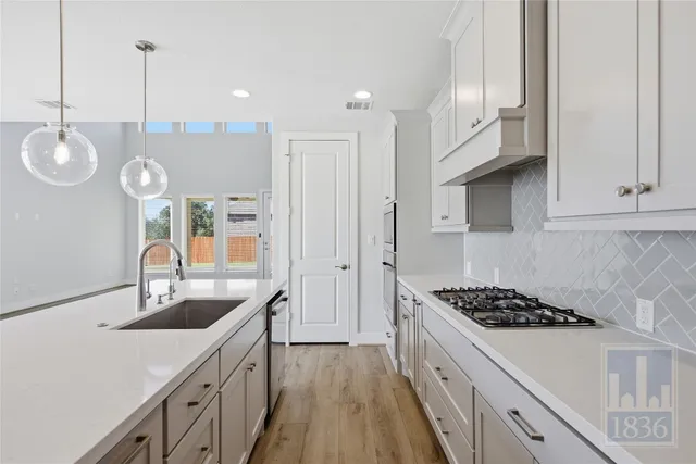 a kitchen with cabinets a sink and appliances