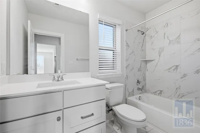 a bathroom with a sink a toilet a mirror a vanity and bathtub