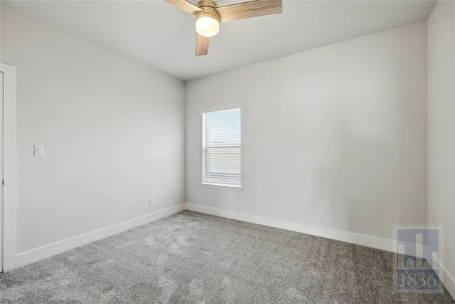 an empty room with a chandelier fan