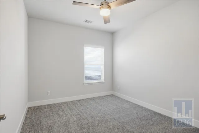 an empty room with a window and a fan
