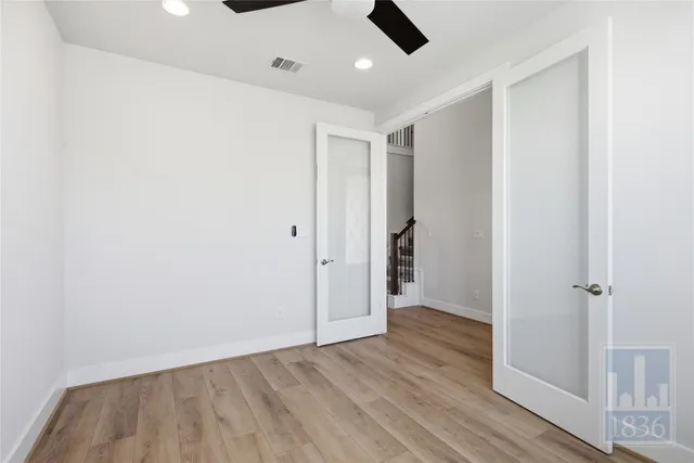an empty room with closet and a ceiling fan