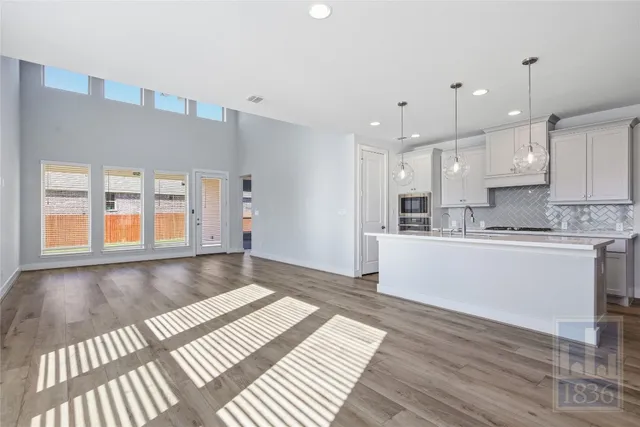 a large kitchen with stainless steel appliances granite countertop a stove a sink and a refrigerator