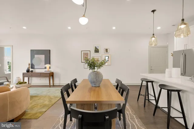 a view of a dining room and livingroom with furniture wooden floor a rug a rug a fireplace