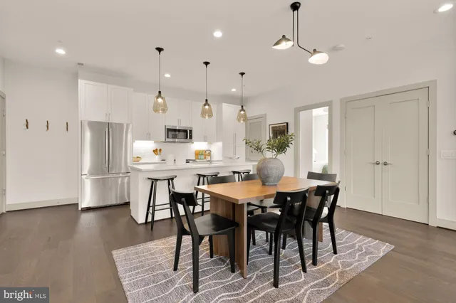 a living room with furniture and a dining table with kitchen view