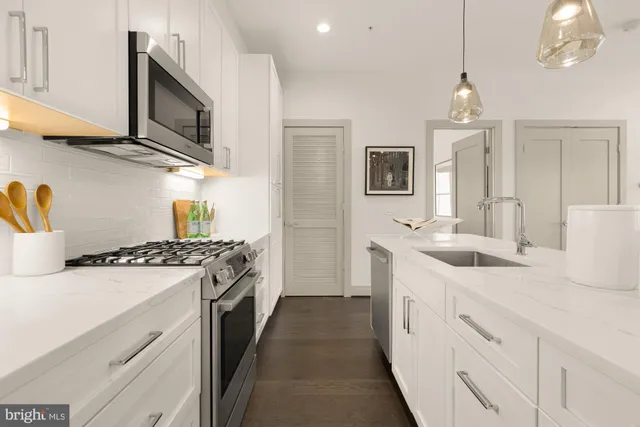 a kitchen with stainless steel appliances granite countertop a sink stove and refrigerator