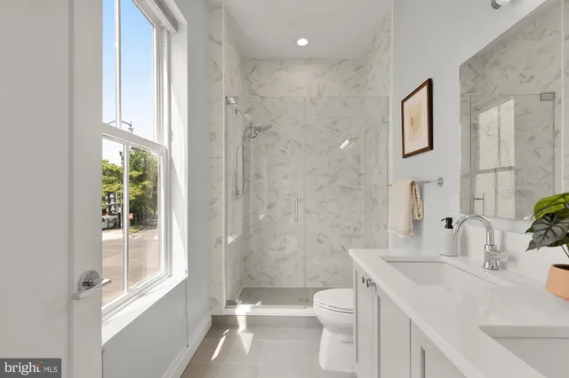 a bathroom with a sink a toilet and a large mirror