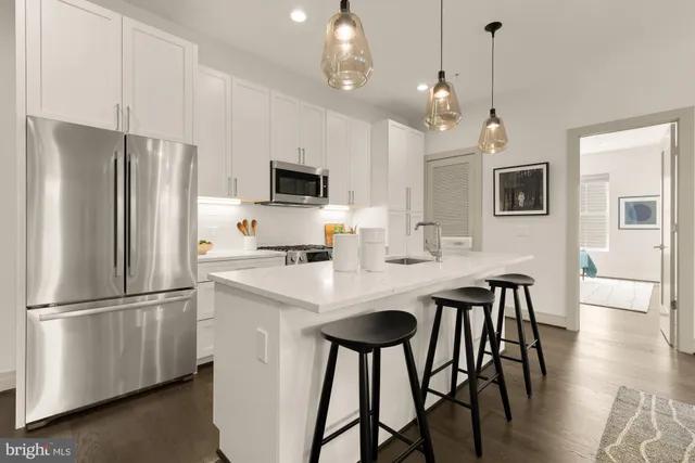 a kitchen with stainless steel appliances a refrigerator a stove a sink and a refrigerator