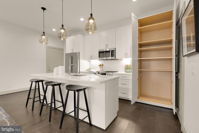 a kitchen with a table chairs refrigerator and microwave