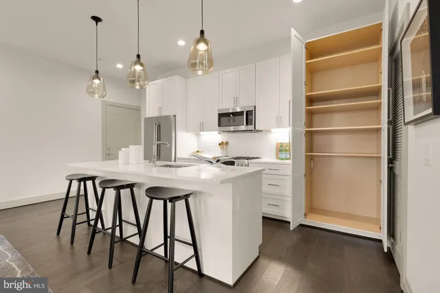 a kitchen with a table chairs refrigerator and microwave