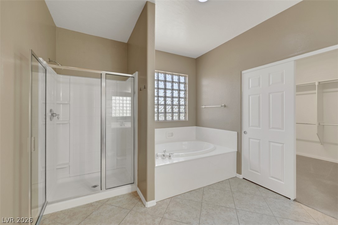2501 Bechamel Place Henderson, NV 89044 - Photo 39 of 50 A well-appointed primary bathroom featuring a spacious walk-in shower, a soaking tub, and tile flooring.