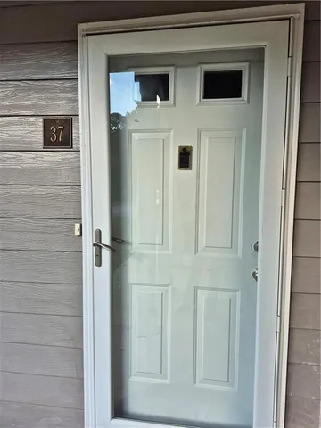 an empty room with wooden floor chandelier fan and windows
