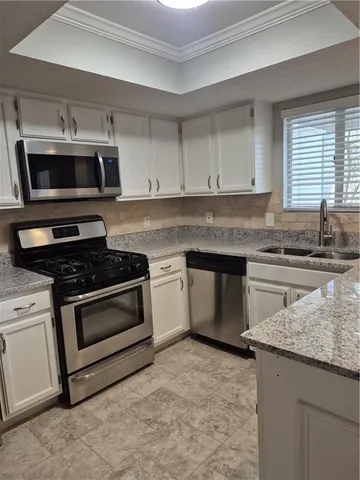 a bathroom with a granite countertop bathtub shower sink vanity and toilet