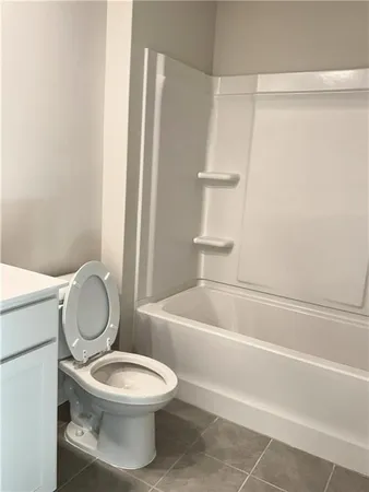 a white toilet sitting next to a bath tub and shower