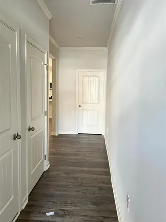 a view of a hallway with wooden floor and closet area
