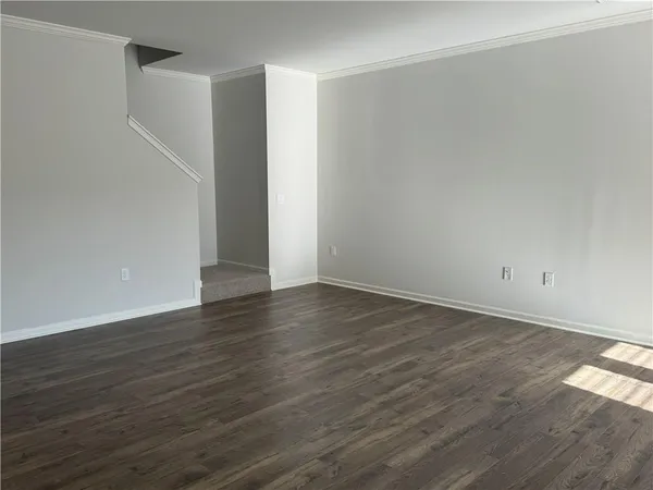 a view of an empty room with wooden floor and closet