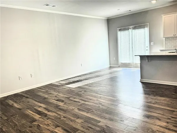 a view of a kitchen with wooden floor and a sink
