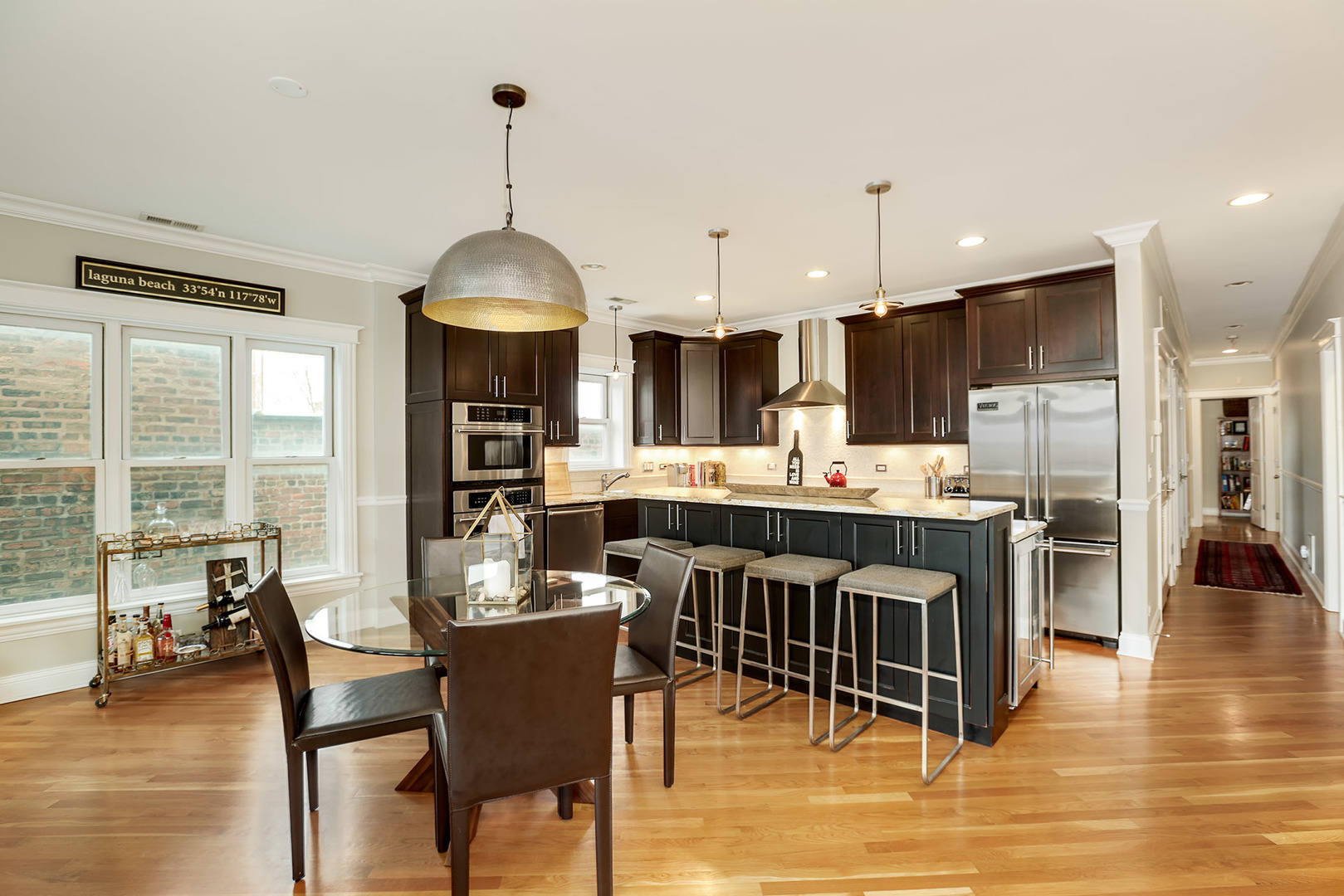456 West Briar Place, Unit 4 Chicago, IL 60657 - Photo 9 of 30 a kitchen with stainless steel appliances kitchen island granite countertop a table chairs and a refrigerator