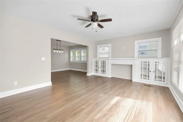 a view of an empty room with window and wooden floor