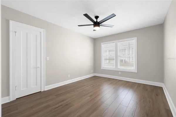 a view of a big room with wooden floor closet and windows