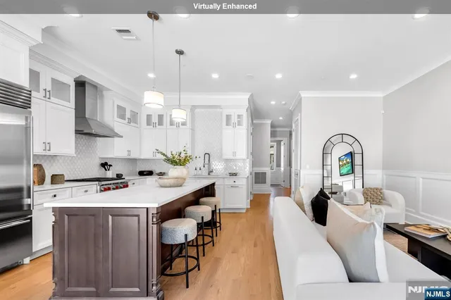 a kitchen with a sink a stove and chairs with kitchen island