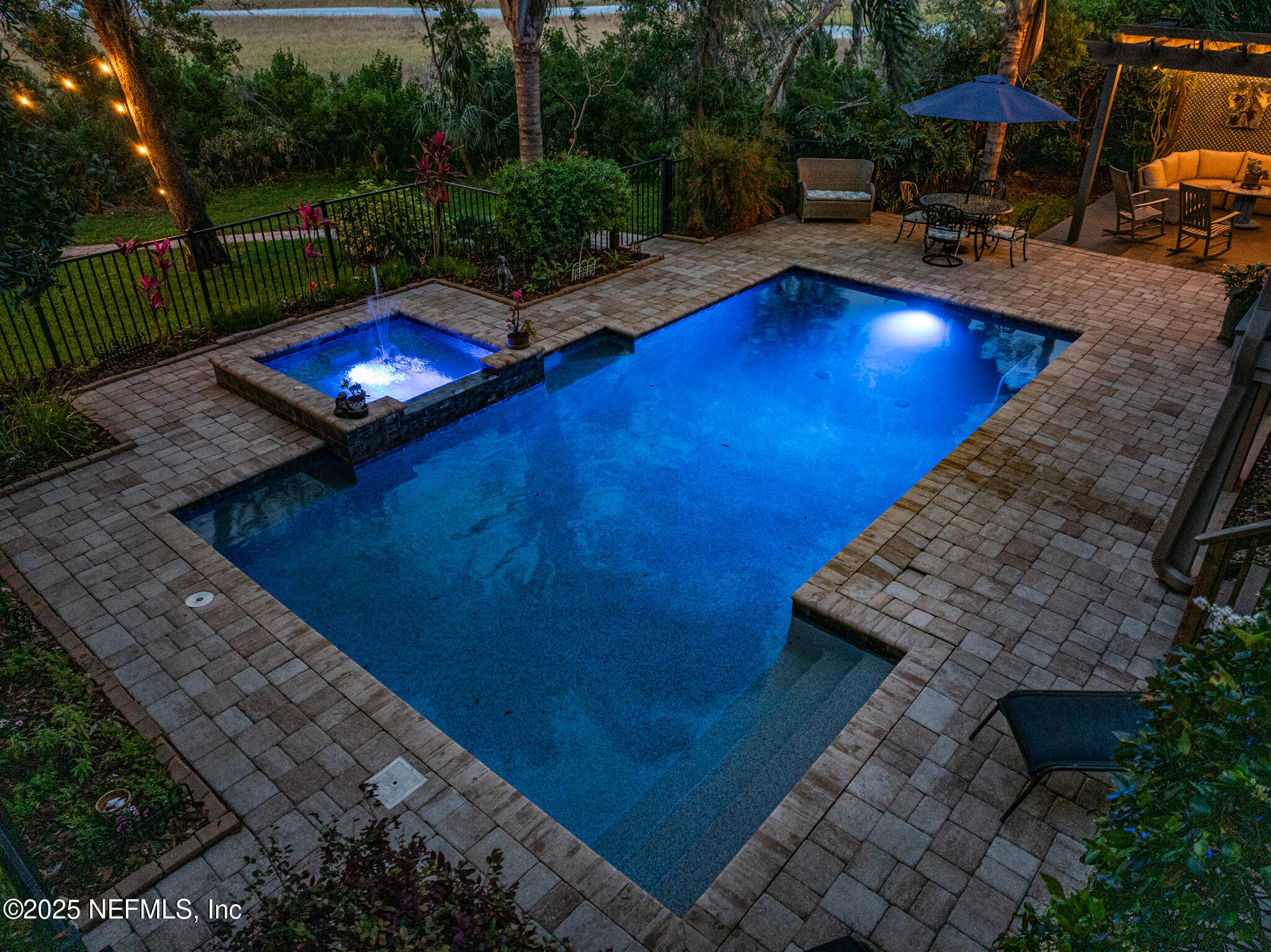 1836 Nightfall Drive Neptune Beach, FL 32266 - Photo 44 of 56 a view of a swimming pool with lawn chairs under an umbrella