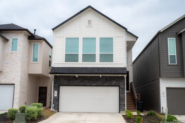 a front view of a house with a garage and balcony