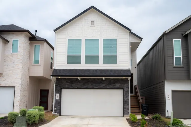 a front view of a house with a garage and balcony