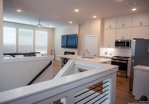a kitchen with kitchen island white cabinets and stainless steel appliances