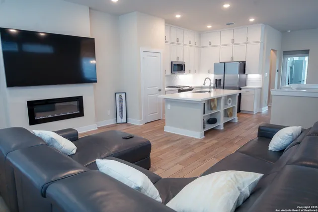 a living room with furniture a flat screen tv and kitchen view