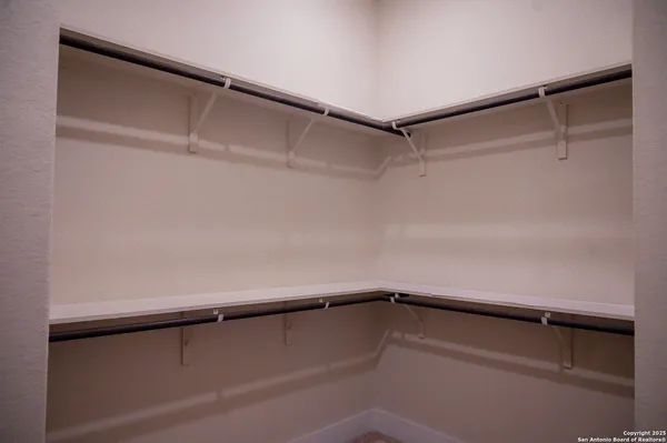 a view of walk in closet with empty racks