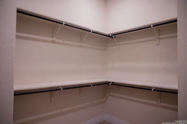 a view of walk in closet with empty racks