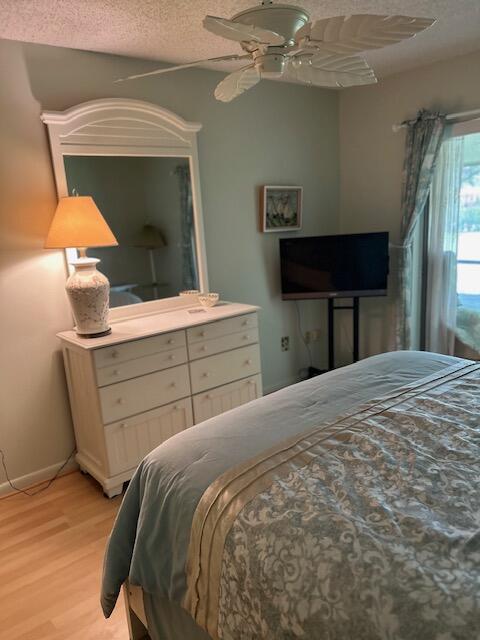 1955 Southwest Palm City Road, Unit H Stuart, FL 34994 - Photo 17 of 22 a bedroom with a bed and a mirror