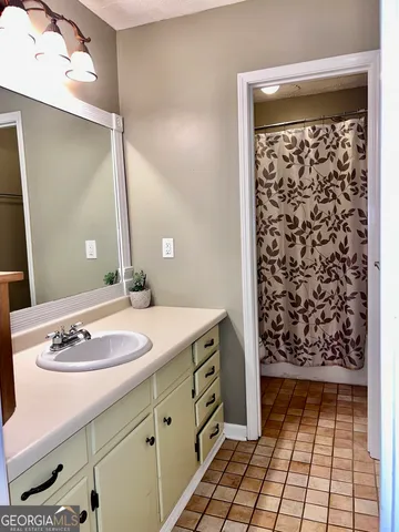 a bathroom with a granite countertop sink a mirror and shower