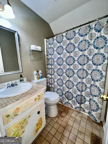 a bathroom with a granite countertop sink and a toilet