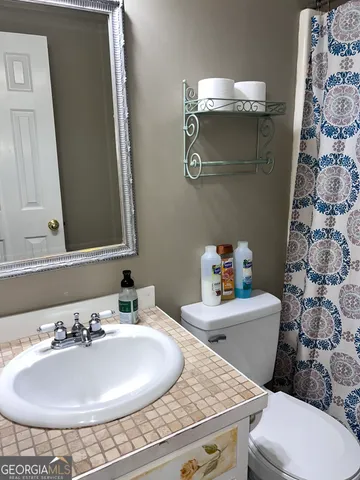 a bathroom with a sink and a mirror with toilet