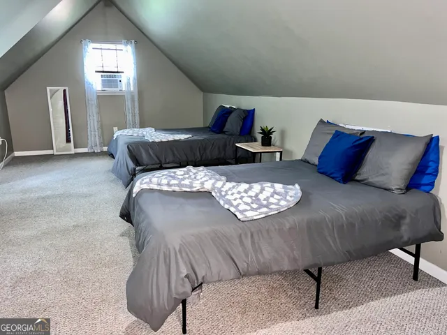 a bed sitting in a bedroom next to a window with lamp
