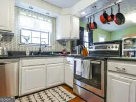 a kitchen with stainless steel appliances granite countertop a stove a sink and a microwave