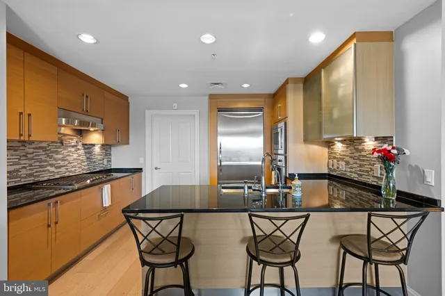 a kitchen with stainless steel appliances a table and chairs