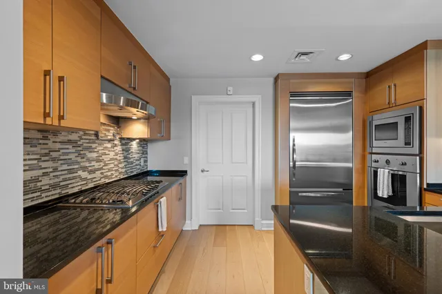 a kitchen with granite countertop a refrigerator and a stove