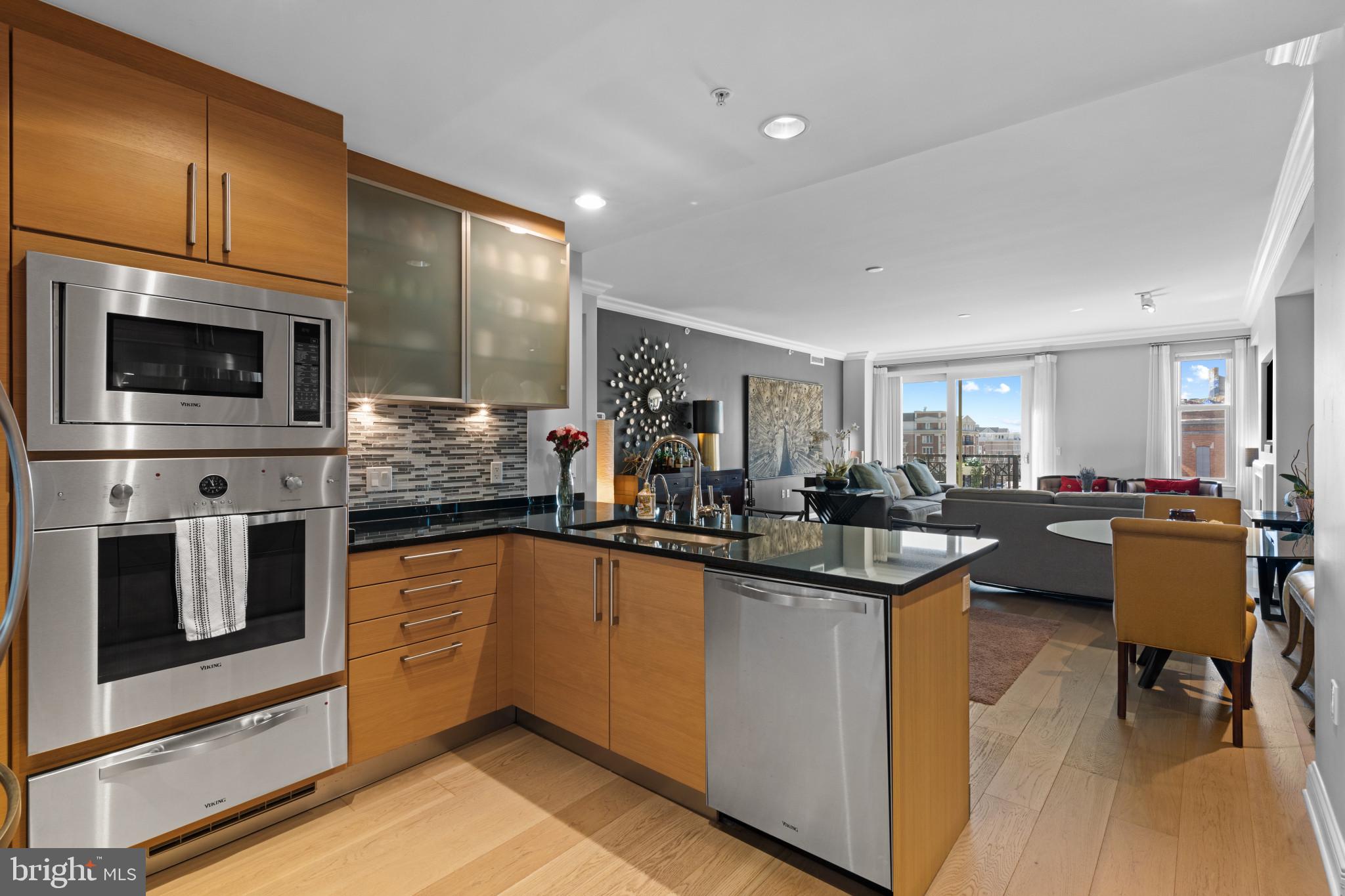 801 Key Highway, Unit T70 Baltimore, MD 21230 - Photo 20 of 43 a kitchen with a sink stainless steel appliances wooden floor and cabinets