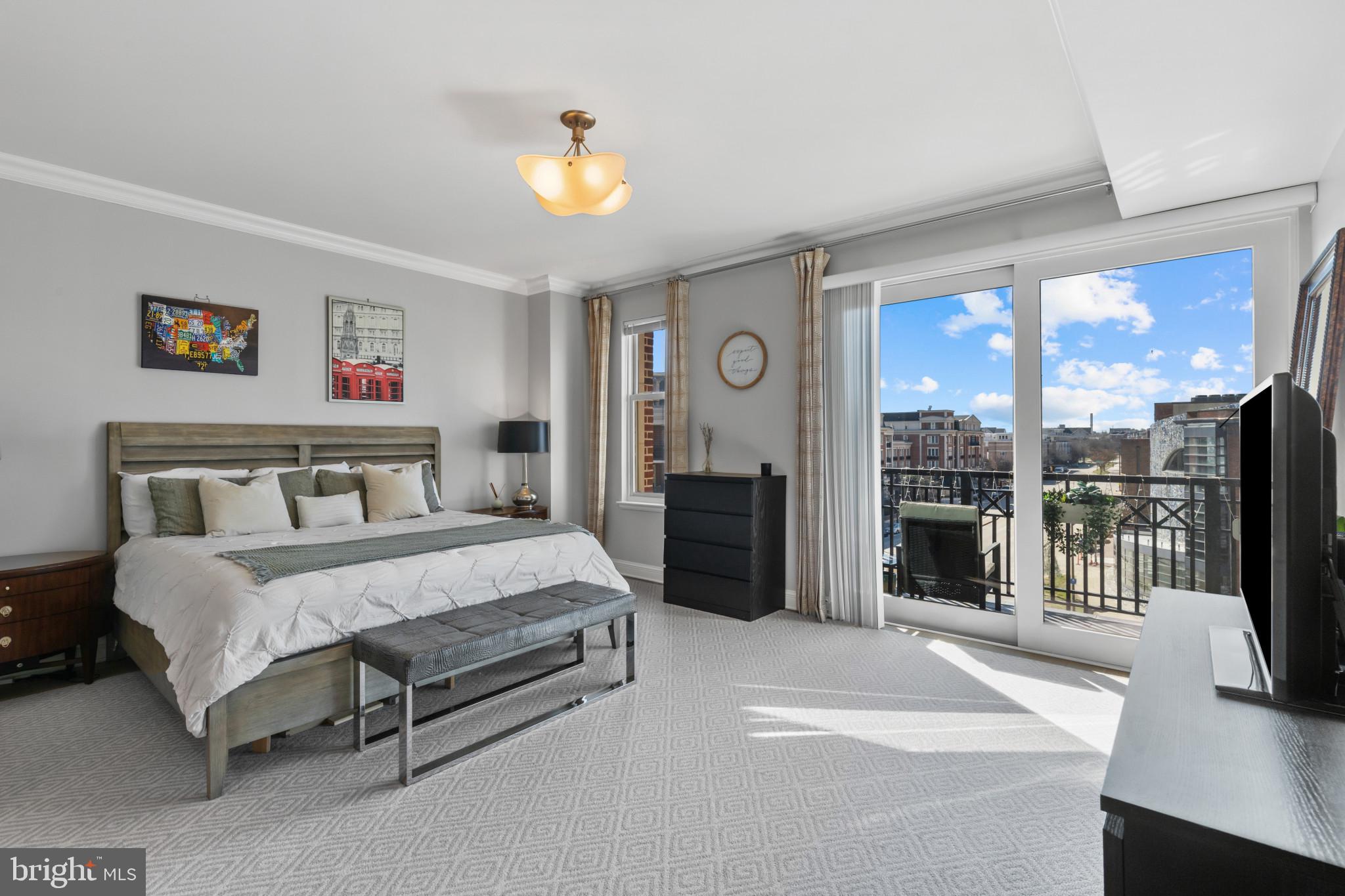 801 Key Highway, Unit T70 Baltimore, MD 21230 - Photo 27 of 43 a spacious bedroom with a bed and a chandelier