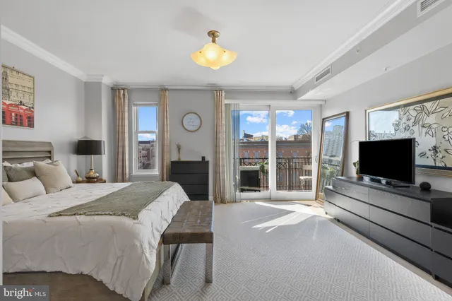 a spacious bedroom with a bed and a flat screen tv