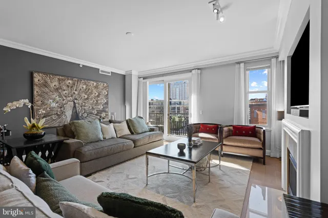 a living room with furniture a flat screen tv and a large window