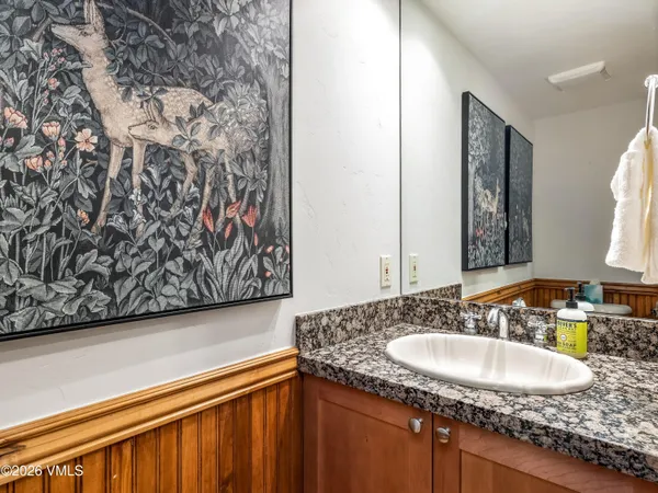 a kitchen with stainless steel appliances granite countertop a refrigerator a stove a sink a dining table and chairs with wooden floor