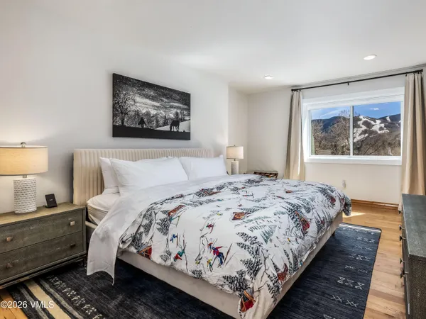 a bedroom with bed and wall painting with wooden floor